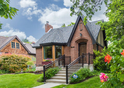 red brick home with peaked roof, half timber exterior features and beautiful landscaping in SLC